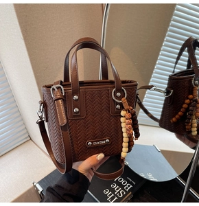 Détail de la texture tressée rétro et breloque en perles de bois sur sac seau marron