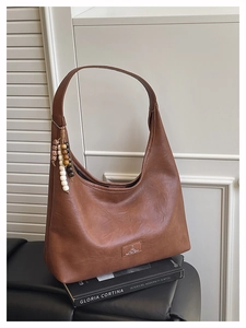 Détail du grand sac cabas en cuir grainé marron rétro avec perles en bois et breloque léopard