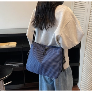 Macro shot of blue checkered canvas tote bag with adjustable shoulder strap