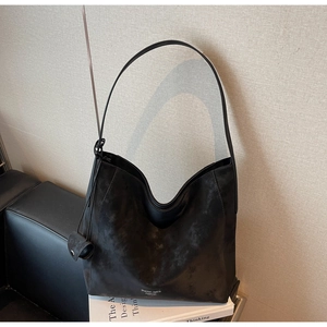 Detailed close-up of a black nubuck hobo bag with a matching coin purse charm
