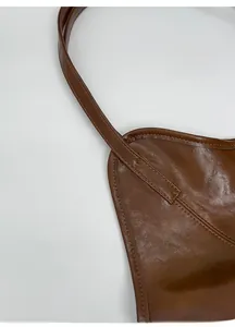 Close-up of reinforced stitching and durable handle connection on brown leather tote bag