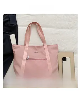 Détail du sac cabas rose en oxford montrant sa capacité avec tablette et mobile