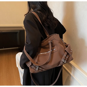 Detail of silver buckles and zipper tassels on vintage large brown leather tote bag