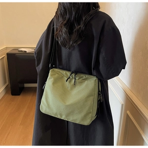 Detail shot of green checkered canvas tote bag showing adjustable wide shoulder straps