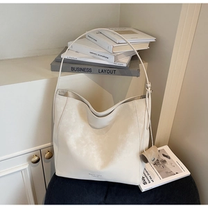 Detail view of cream white tote bag with fine leather texture and detachable mini pouch