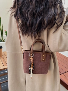 Sac seau en daim marron vintage avec coutures matelassées et pompon en perles de bois