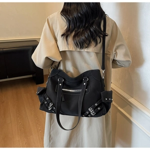 Close-up of black crossbody bag with functional utility pockets and silver hardware detailing