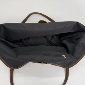 Vertical top view showing spacious black nylon interior with a gold zipper inner pocket