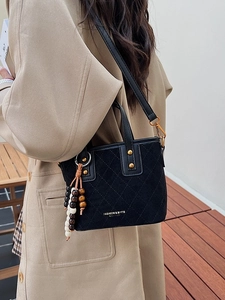 Sac seau matelassé en daim noir avec pompon perlé et lettrage logo doré élégant