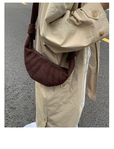 Détail montrant la texture en daim marron foncé et les coutures segmentées du sac à main