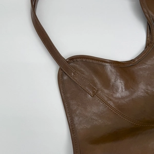 Detail of vintage brown leather tote showing fine texture and reinforced stitching