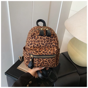 Close-up of leopard print backpack with soft faux fur texture and gold hardware