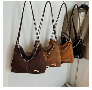 Detail of vintage tote bags in coffee and caramel suede with silver heart chain accents