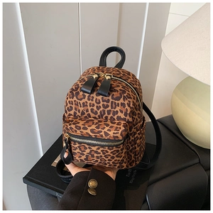 Detail of leopard print mini backpack with gold zippers and black leather accents