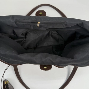 Interior view of large leather tote bag with black lining and inner zipper pocket