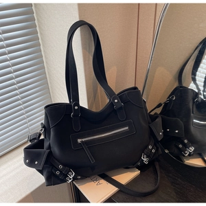 Detail view of retro matte black tote bag with silver studs and multiple zipper pockets