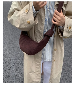 Détail du sac croissant marron foncé avec plis matelassés et bandoulière nouée sur modèle