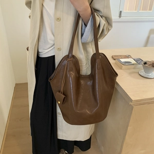 Close-up of vintage dark brown faux leather tote bag with small hanging coin pouch