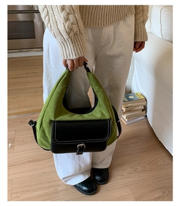 Dettaglio borsa hobo in camoscio verde con tasca in pelle nera e fibbia in metallo argento