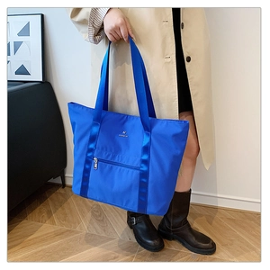 Détail du grand sac cabas en tissu Oxford bleu avec poche avant zippée et sangle