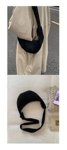 Détail du sac croissant minimaliste en daim noir avec large bandoulière et fermeture éclair