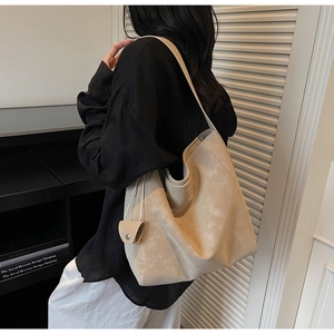 Detail shot of a beige large-capacity tote bag with side coin purse on a model