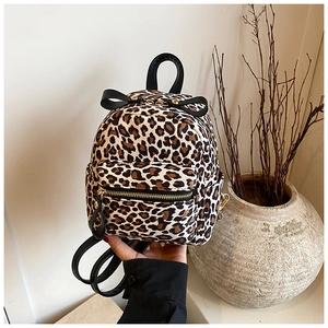 Detailed macro view of leopard print backpack with black bow and gold zipper