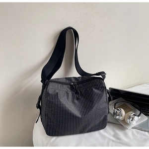 Detailed view of the plaid canvas tote bag with adjustable strap and smooth zipper closure