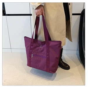 Détail du sac cabas bordeaux en tissu oxford avec bandoulières et logo en métal