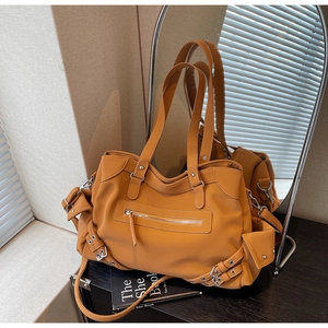 Detail of ginger matte tote bag with silver zippers and pockets in home setting