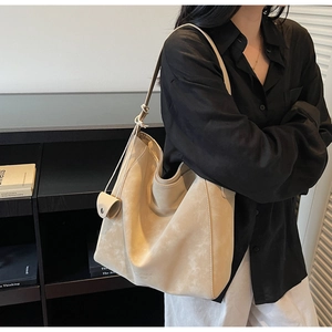 Minimalist beige tote bag with soft texture and knotted strap detail for daily commute