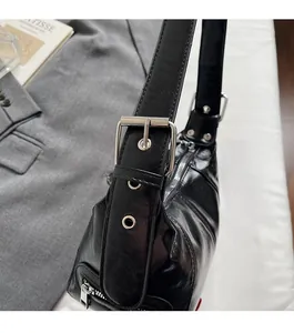 Detailed macro view of black glossy leather bag side with silver metallic buckle hardware