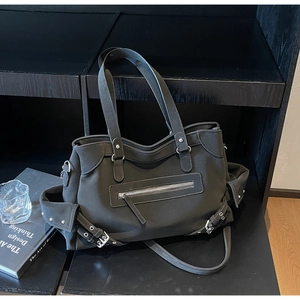 Detail of matte black tote bag with silver buckles and large utility zipper pocket