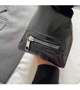 Detail of premium black leather shoulder bag showing the silver metal side zipper