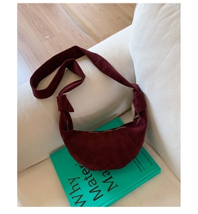 Détail du sac dumpling bordeaux avec texture en velours côtelé et bandoulière nouée