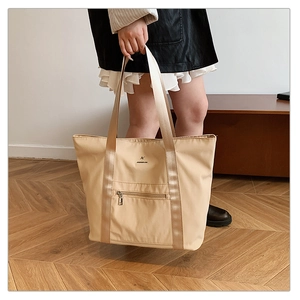 Détail du grand sac cabas beige en tissu Oxford avec poche frontale zippée et anses