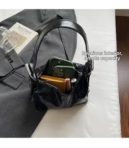 Interior view of black glossy dumpling bag showing large capacity with personal essentials