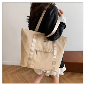 Détail d'un grand sac cabas beige en tissu Oxford avec texture nylon et poche zippée