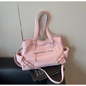 Detail view of pink matte leather tote bag featuring functional zippers and metallic hardware