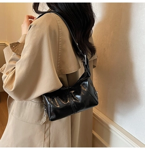Black leather underarm bag featuring glossy finish and silver metal zipper details