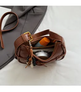 Interior detail of brown vintage saddle bag showing capacity for cosmetics and accessories