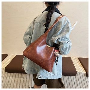 Close-up of vintage brown leather tote bag with Forever and Bags text and plush bear