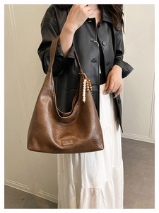 Détail du sac cabas vintage marron foncé en similicuir texturé avec breloque perlée