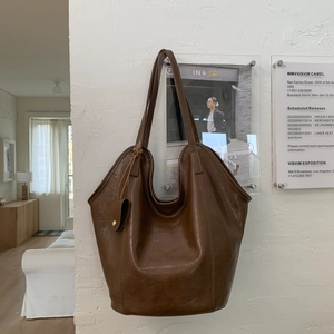 Detail of vintage caramel brown hobo tote bag with a small matching pouch and gold buckle