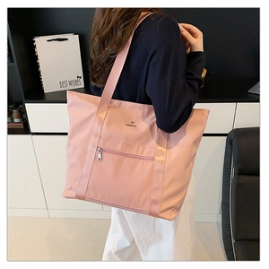 Détail du grand sac cabas en nylon rose pâle imperméable avec poche zippée et sangle large