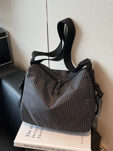 Black and white checkered canvas tote bag with adjustable shoulder strap and double zipper