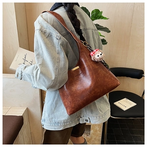 Brown retro PU leather tote bag with a cute plush pendant and metallic accent