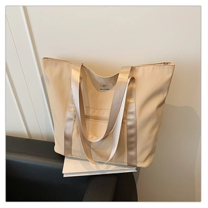 Gros plan sur le sac cabas beige en Oxford avec sangles ruban et design minimaliste