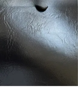 Detailed macro shot showing the fine texture of black pebbled leather handbag material