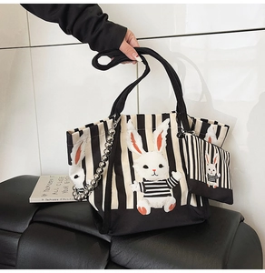 Dettaglio della borsa tote in tela a righe con coniglio 3D e mini pochette coordinata